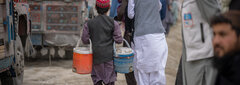 KANDAHAR, SOUTHERN AFGHANISTAN, An Afghan child sells water to returning migrants at Spin Boldak border crossing in Kandahar.