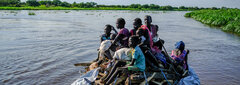 Sobat River, South Sudan, Flood-displaced migrants use a tarpaulin to float down the Sobat River in search of higher ground