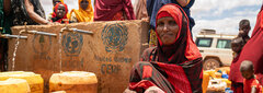 Kaharey IDP site, Doolow District, Somalia, A woman waits for her kettle to fill. The water supply is enough for only 40 per cent of the site’s population. IDPs with no access to clean water rely on sources outside their settlement areas, which mainly comprise untreated water from a river that’s almost 5 km away. 