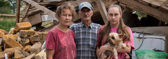 Kyiv Oblast, Ukraine, Oksana, Yurii and their daughter Svitlana at their destroyed home in Nalyvaikivka, in Kyiv Oblast. The family was hiding in their underground cold room when the house was hit by two missiles.