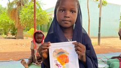 Elgeraif, Khartoum, Sudan, A girl child showing her drawings at the ERR in Elgeraif