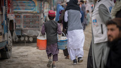 KANDAHAR, SOUTHERN AFGHANISTAN, An Afghan child sells water to returning migrants at Spin Boldak border crossing in Kandahar.