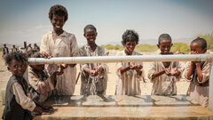 Ashat village, Tokar locality, Sudan, Children and adults at a water facility that is open all day and serves about 350 households. 