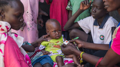 Malakal County, Upper Nile State, A health worker screening a child for malnutrition.